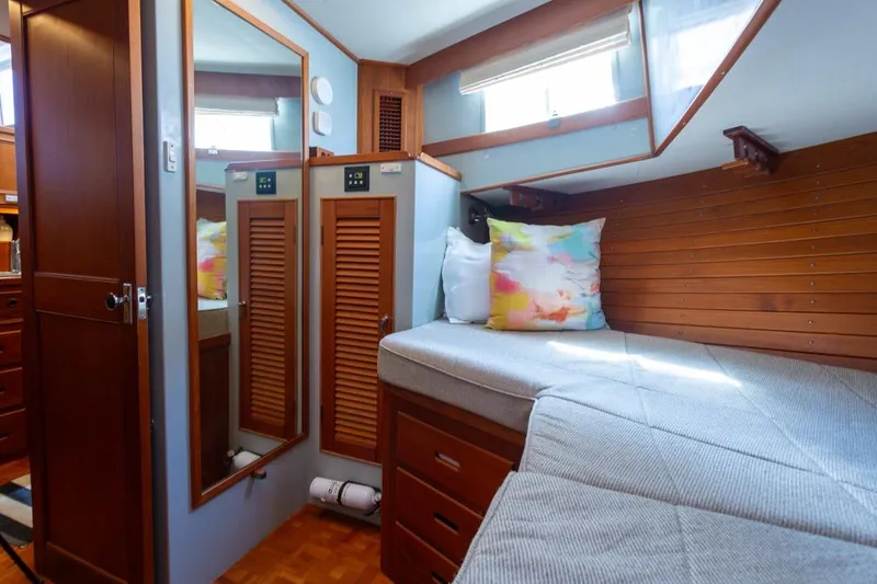 Slide: The Image of Cozy cabin interior of 1993 Grand Banks 46 Motoryacht with wooden accents and colorful pillow. - 46