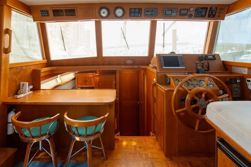 Slide: The Image of 1993 Grand Banks 46 Motoryacht helm with wooden interior and nautical decor. - 56