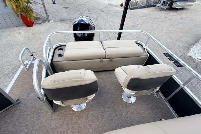 Slide: The Image of 2022 Sun Tracker Fishin' Barge 22 DLX interior with seating and motor view. - 17