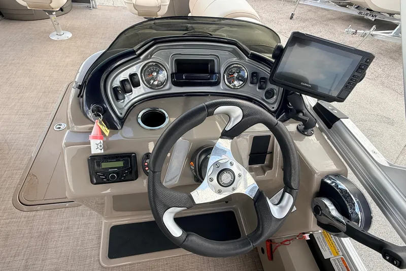 Slide: The Image of 2022 Sun Tracker Fishin' Barge 22 DLX dashboard with steering wheel and Garmin display. - 20
