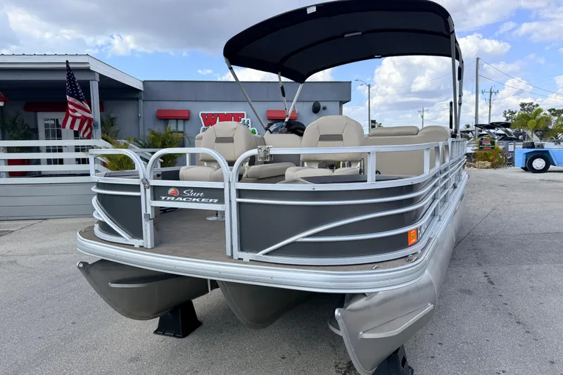 Slide: The Image of 2022 Sun Tracker Fishin' Barge 22 DLX pontoon boat with canopy, parked outdoors. - 3