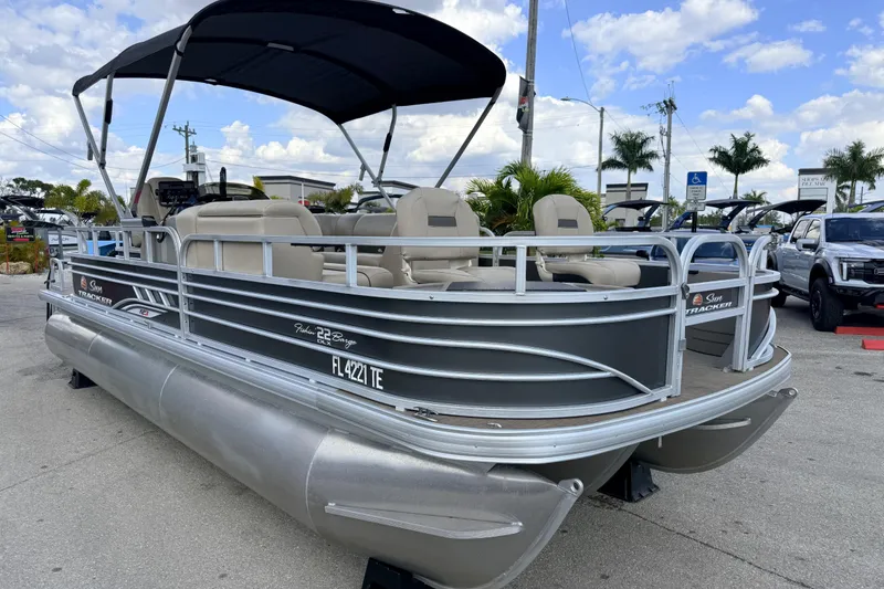 Slide: The Image of 2022 Sun Tracker Fishin' Barge 22 DLX pontoon boat with canopy, parked outdoors. - 5