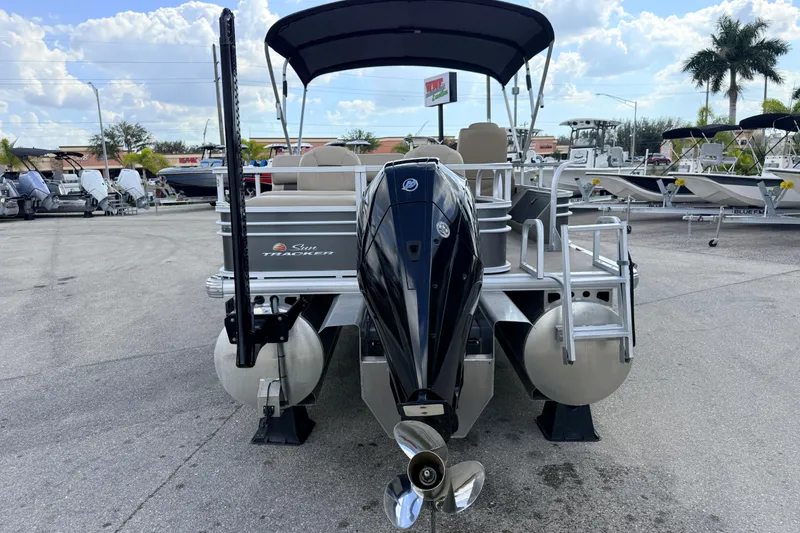 Slide: The Image of 2022 Sun Tracker Fishin' Barge 22 DLX pontoon boat with outboard motor, docked outdoors. - 7