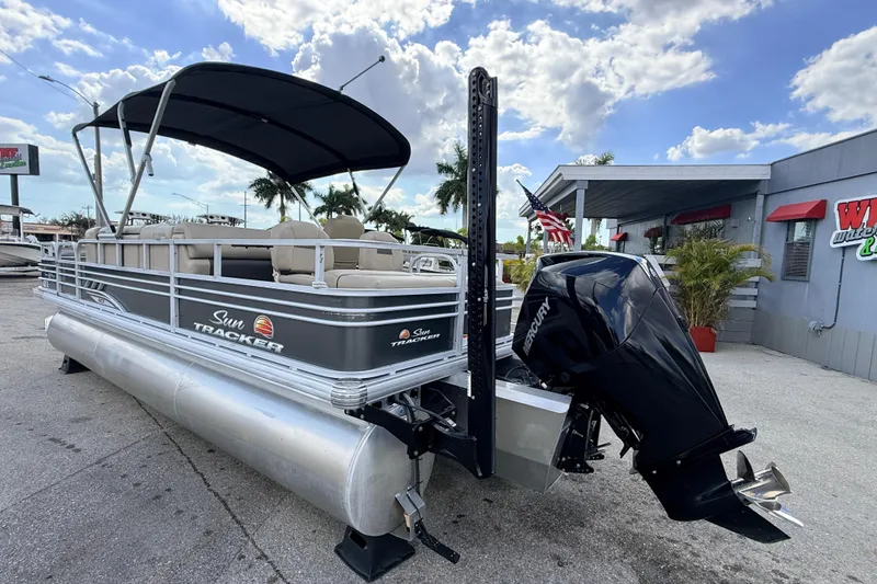 Slide: The Image of 2022 Sun Tracker Fishin' Barge 22 DLX pontoon boat with Mercury engine, docked outdoors. - 9