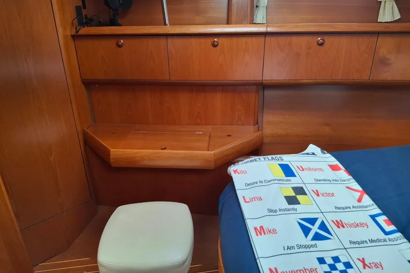 Slide: The Image of Interior of 2009 Jeanneau Sun Odyssey 54 DS with wooden cabinetry and nautical flag chart. - 16