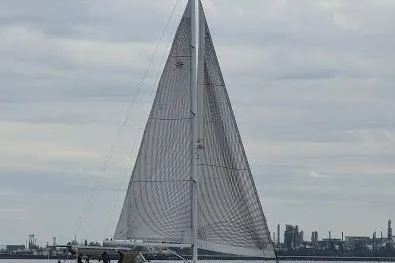 Slide: The Image of 2009 Jeanneau Sun Odyssey 54 DS sailing on a cloudy day near industrial skyline. - 2