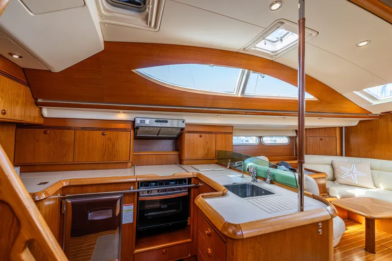 Slide: The Image of Cozy cabin interior of 2009 Jeanneau Sun Odyssey 54 DS with wooden furnishings and blue bedding. - 31
