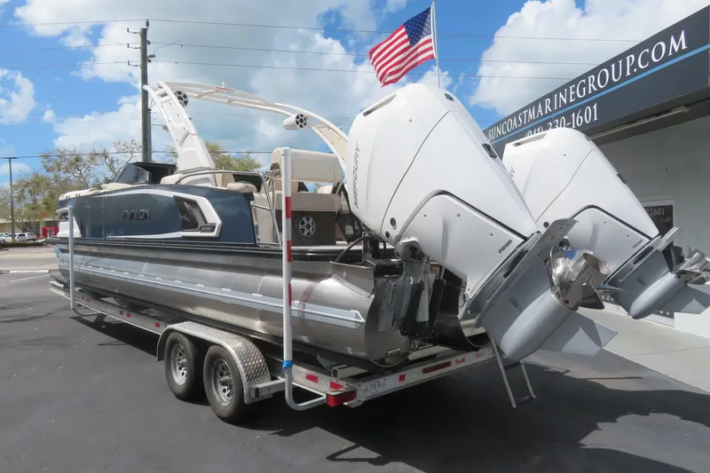 Slide: The Image of 2026 Avalon Excalibur LTD Quad Lounger on trailer with dual outboard motors. - 13