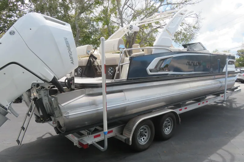Slide: The Image of Avalon Excalibur LTD Quad Lounger 2026 on trailer with Mercury engine. - 15
