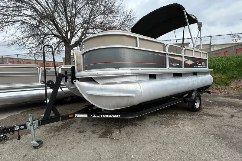 Slide: The Image of 2019 Sun Tracker Party Barge 18 DLX interior storage compartment with beige seating. - 29