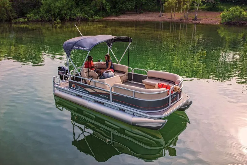 Slide: The Image of 2019 Sun Tracker Party Barge 18 DLX pontoon boat on trailer at sunset. - 7