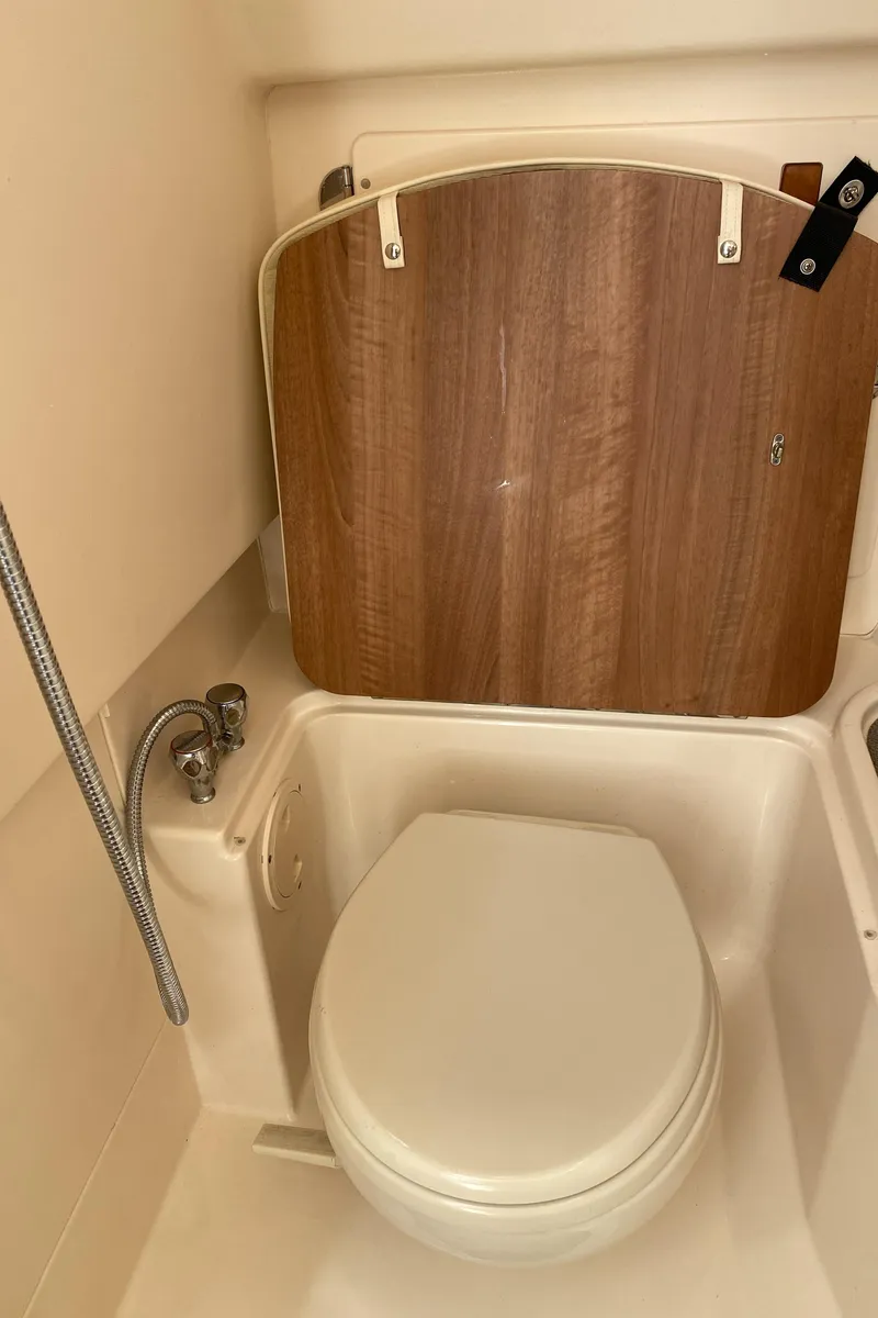 Slide: The Image of 2017 Grady-White Freedom 375 boat bathroom with toilet and wooden panel. - 40