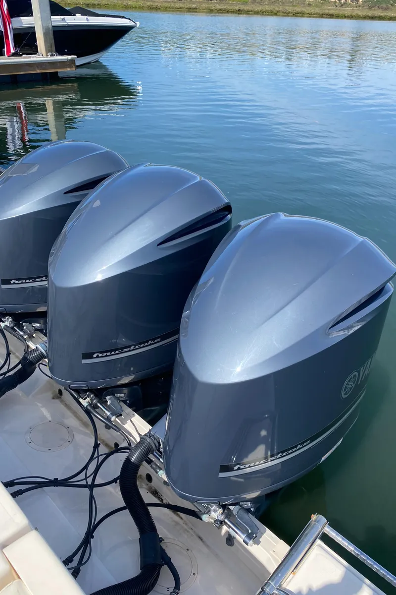 Slide: The Image of 2017 Grady-White Freedom 375 with triple outboard engines docked on calm water. - 8