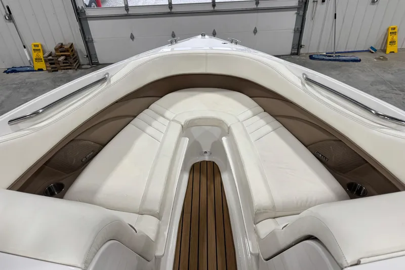 Slide: The Image of 2007 Cobalt 282 boat interior with white seating and wood flooring in a garage. - 12