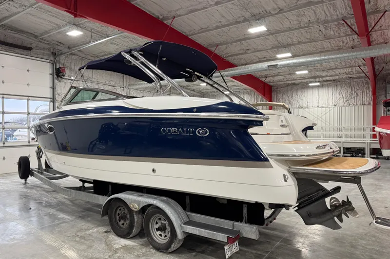 Slide: The Image of 2007 Cobalt 282 boat in a garage, blue and white exterior, on a trailer. - 3