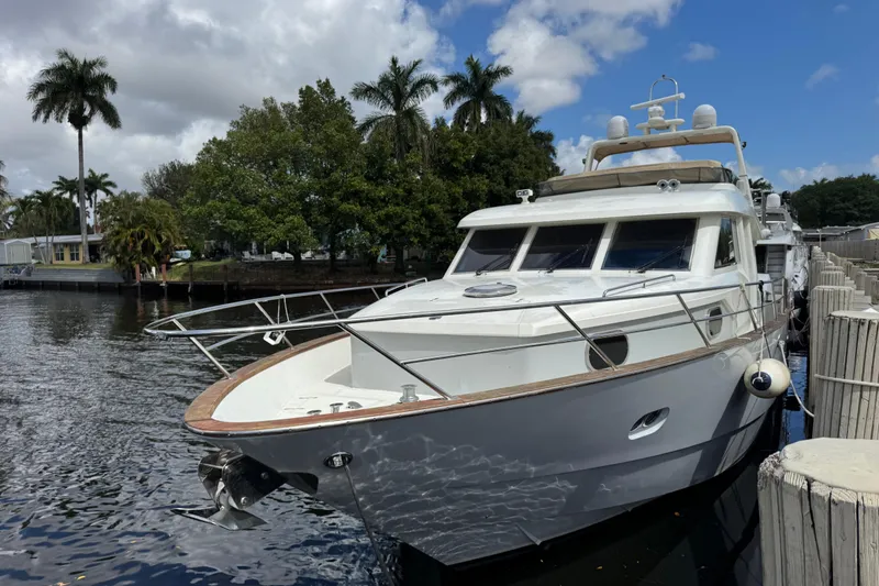 The Image of Custom 2003 Sea Star Pilot House yacht docked by palm trees under a blue sky. - 1