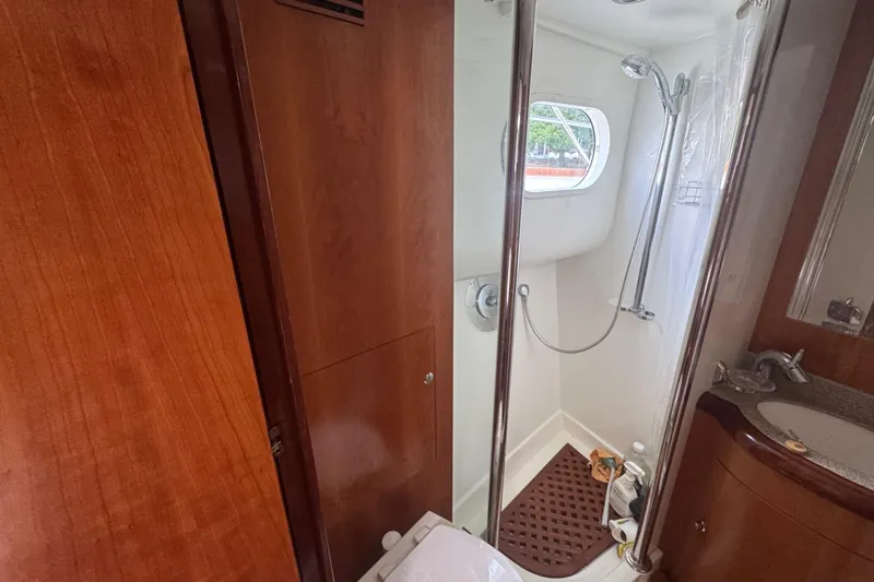 Slide: The Image of 2003 Custom Sea Star Pilot House bathroom with shower, wooden cabinetry, and sink. - 19