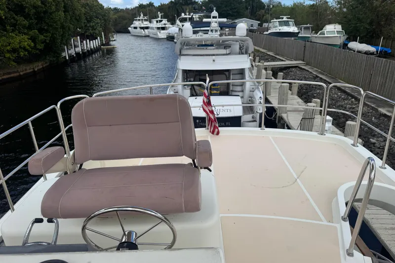 Slide: The Image of 2003 Custom Sea Star Pilot House yacht docked, featuring a spacious deck and comfortable seating. - 24