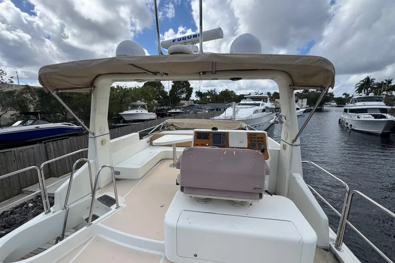 Slide: The Image of 2003 Custom Sea Star Pilot House boat docked, featuring spacious deck and navigation equipment. - 27