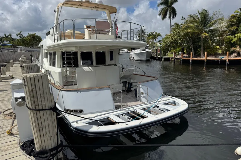 Slide: The Image of 2003 Custom Sea Star Pilot House yacht docked by palm trees and calm water. - 5