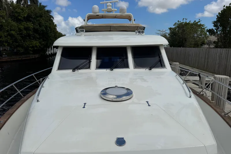 Slide: The Image of Front view of 2003 Custom Sea Star Pilot House boat docked by a wooden fence. - 6