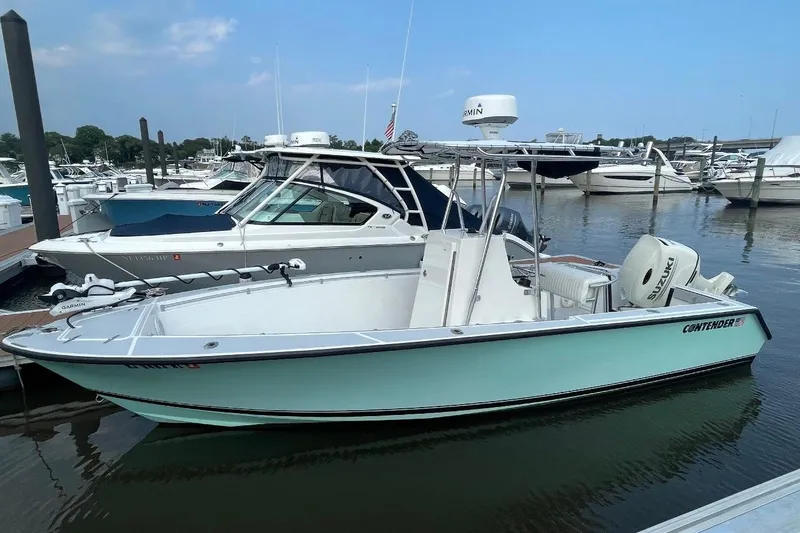 The Image of 1998 Contender 21 Open boat docked at marina, featuring Suzuki outboard motor. - 0