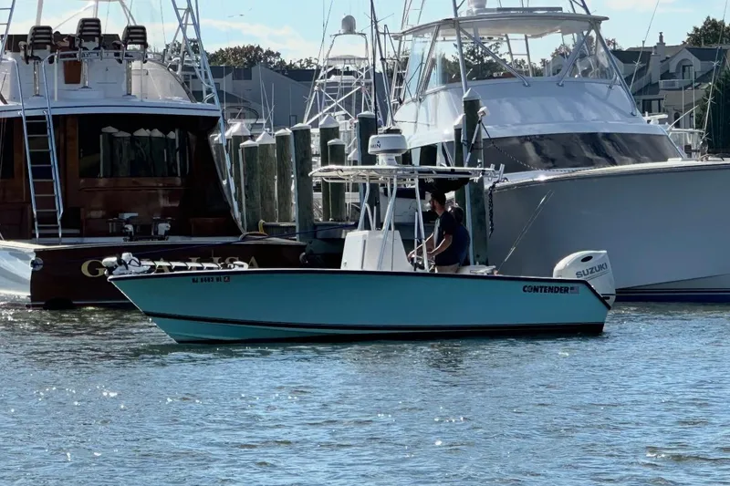 Slide: The Image of 1998 Contender 21 Open boat with Suzuki engine docked in marina. - 2
