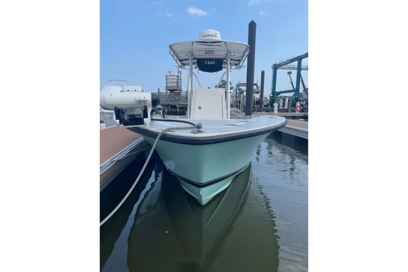 Slide: The Image of 1998 Contender 21 Open boat docked, featuring Garmin equipment, calm water reflection. - 3