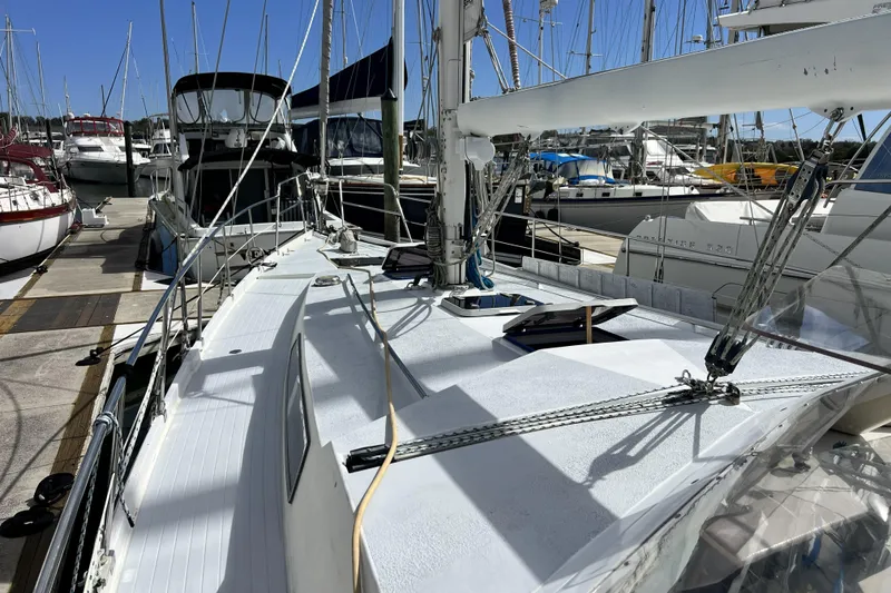 Slide: The Image of 1986 Amel Mango sailboat docked at a marina, surrounded by other boats. - 11