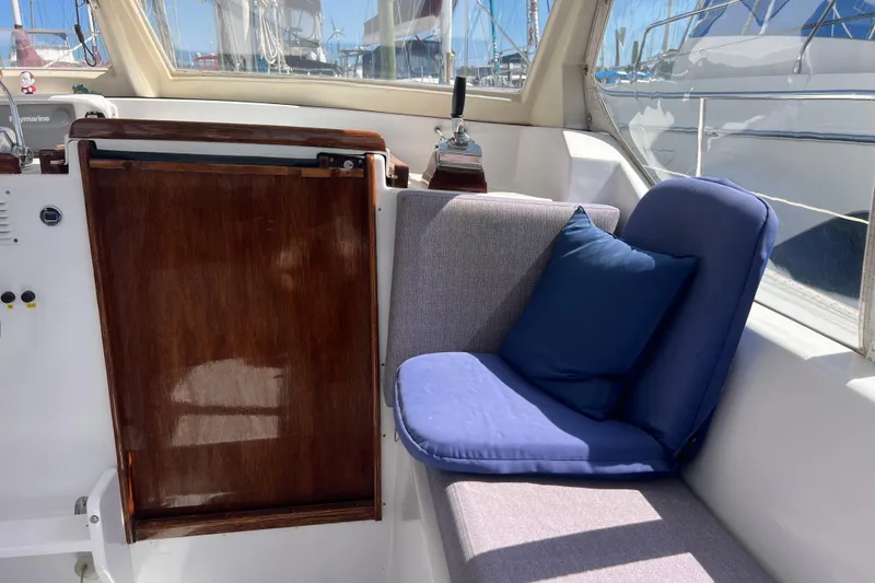Slide: The Image of Cozy seating area on 1986 Amel Mango yacht with blue cushions and wooden panel. - 15