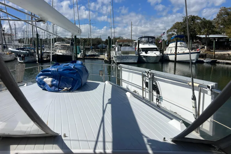 Slide: The Image of 1986 Amel Mango sailboat docked at marina, surrounded by other boats under a blue sky. - 17