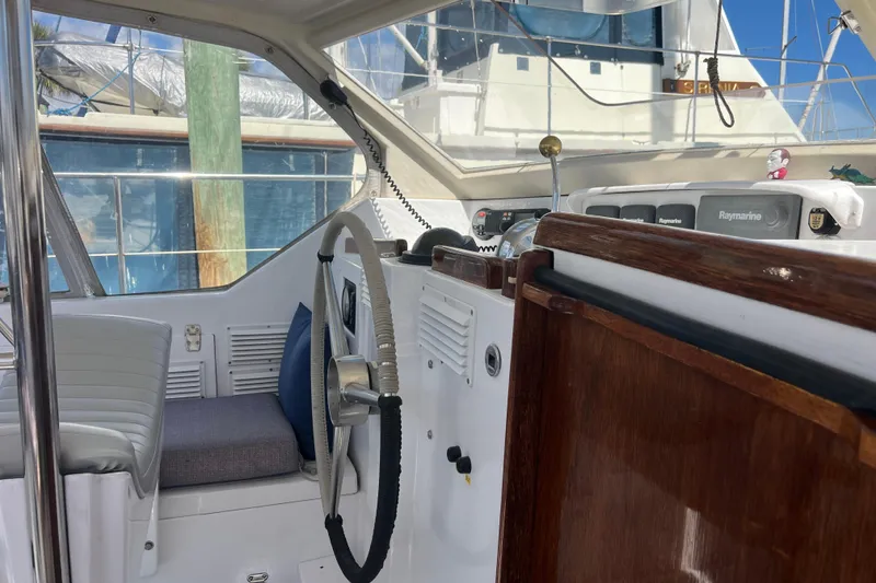 Slide: The Image of Interior view of 1986 Amel Mango sailboat cockpit with steering wheel and navigation equipment. - 19
