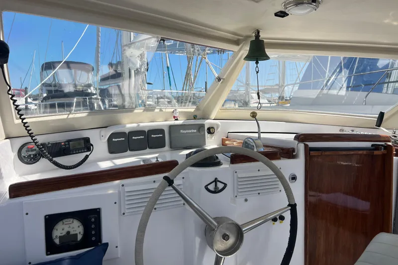 Slide: The Image of Interior view of 1986 Amel Mango sailboat cockpit with steering wheel and navigation equipment. - 22