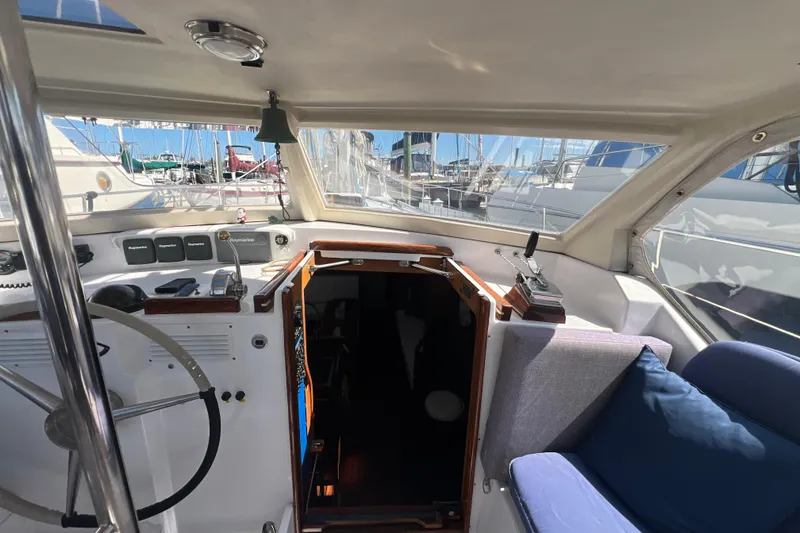 Slide: The Image of Cockpit of 1986 Amel Mango sailboat with steering wheel and navigation equipment. - 26