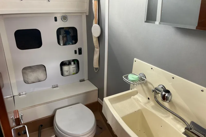 Slide: The Image of Compact bathroom in 1986 Amel Mango yacht with toilet, sink, and storage shelves. - 27