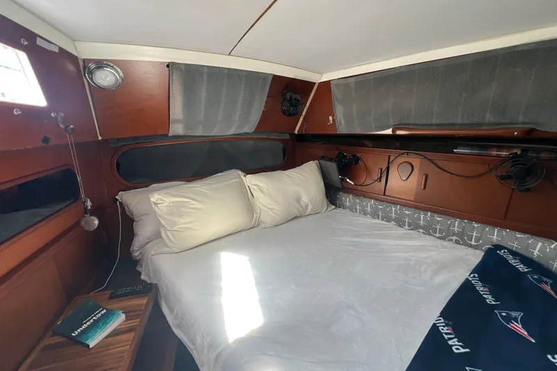 Slide: The Image of Cozy cabin interior of 1986 Amel Mango sailboat with bed and nautical decor. - 28