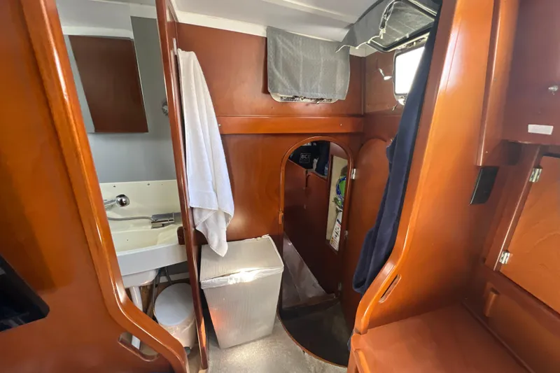 Slide: The Image of Interior of 1986 Amel Mango sailboat with wooden cabinetry and compact bathroom. - 30