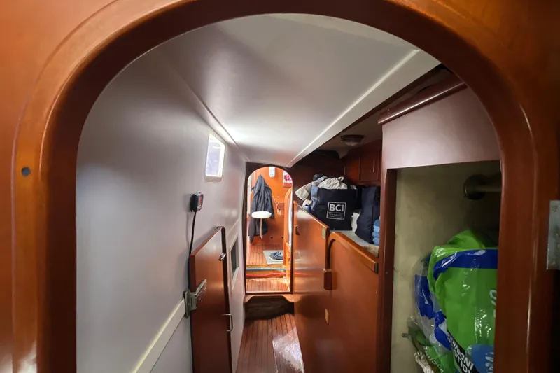 Slide: The Image of Interior view of 1986 Amel Mango sailboat, featuring wooden finishes and storage areas. - 31