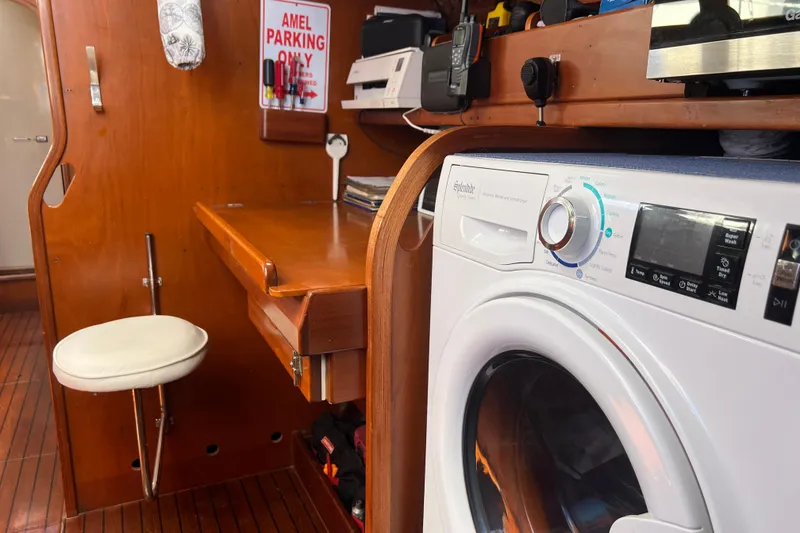 Slide: The Image of Interior of 1986 Amel Mango yacht with washing machine and wooden desk area. - 34