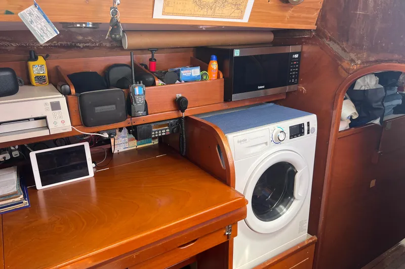 Slide: The Image of Interior of 1986 Amel Mango yacht with washing machine, microwave, and navigation equipment. - 35