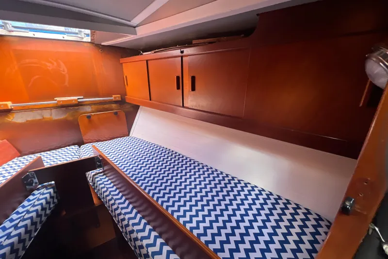 Slide: The Image of Cozy cabin interior of 1986 Amel Mango sailboat with chevron-patterned cushions. - 46