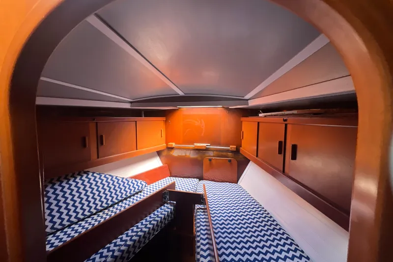 Slide: The Image of Interior of 1986 Amel Mango sailboat with wooden cabinets and chevron-patterned cushions. - 47