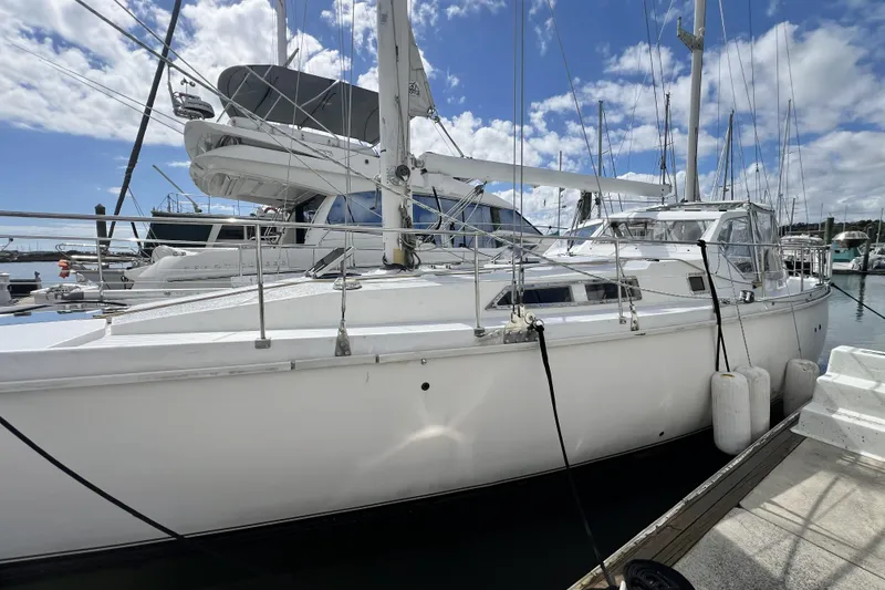 Slide: The Image of 1986 Amel Mango sailboat docked at marina under blue sky. - 51
