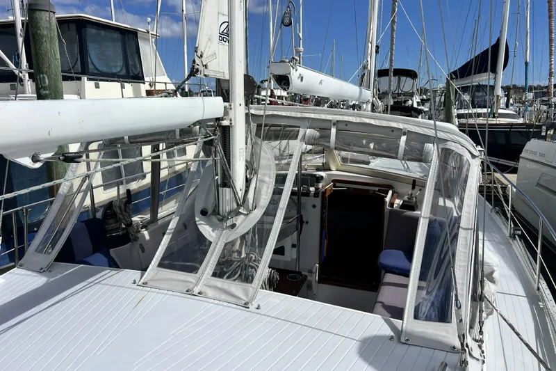 Slide: The Image of 1986 Amel Mango sailboat docked at marina, featuring cockpit and rigging. - 54