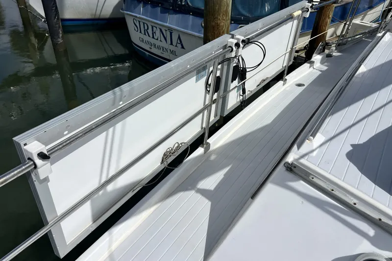 Slide: The Image of Deck of 1986 Amel Mango sailboat with docked boat in background. - 55