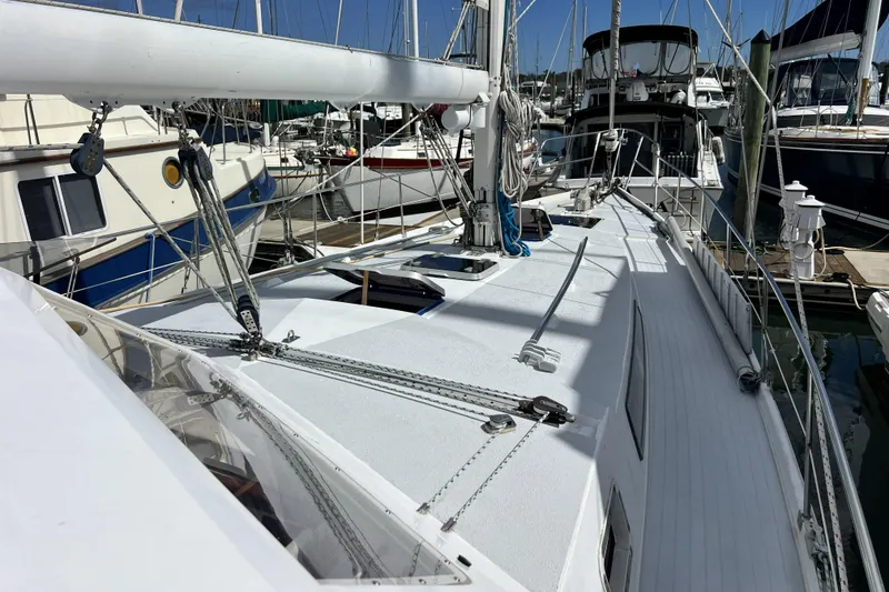Slide: The Image of 1986 Amel Mango sailboat docked in marina, showcasing deck and rigging. - 58