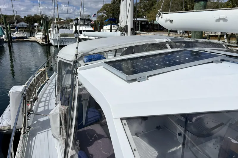 Slide: The Image of 1986 Amel Mango sailboat with solar panel docked at marina. - 61