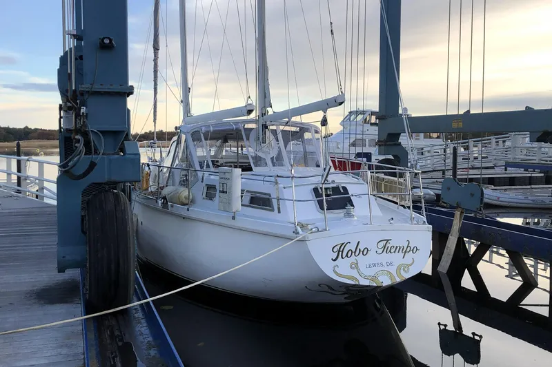 Slide: The Image of 1986 Amel Mango sailboat "Hobo Tiempo" docked at marina during sunset. - 62