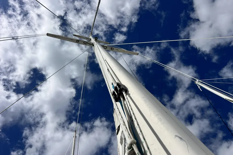 Slide: The Image of Sailboat mast of 1986 Amel Mango against a cloudy blue sky. - 7