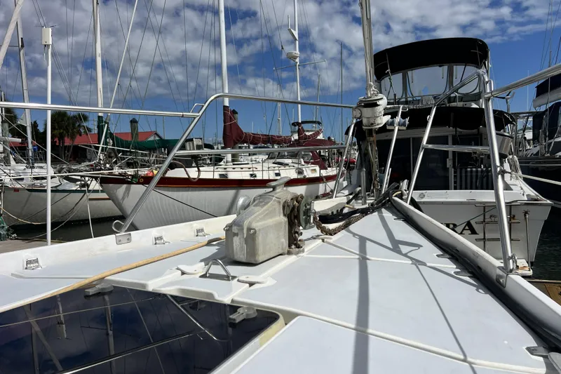 Slide: The Image of Sailboats docked at marina, featuring 1986 Amel Mango under clear blue sky. - 8
